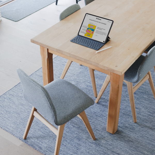 Tablet on modern wooden desk with grey chairs