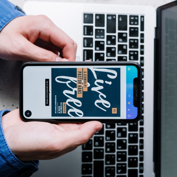 Person holding smartphone displaying 'Live Free' quote